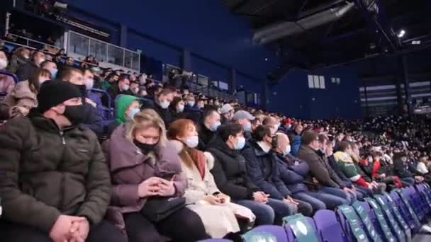 Зрители с хоккейными болельщиками в масках на соревнованиях — стоковое видео