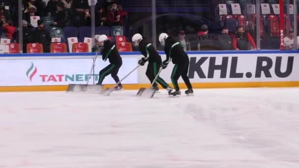 Trabajadores con palas patinan y limpian la superficie de pista de hielo — Vídeos de Stock