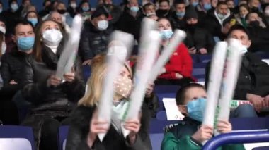 Anne ve oğul hokey takımını destekleyen şişme çubukları alkışlıyor.