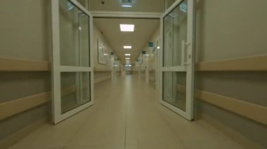 Hastalar için çağdaş klinik binasının boş, aydınlık koridoru ve resepsiyonist tezgahı.