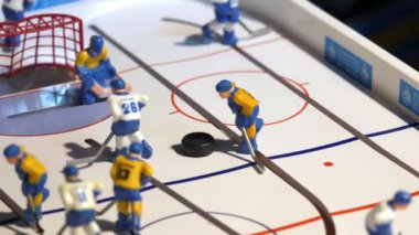Hokey oyuncusunun minyatür figürü, oyun sahasında küçük bir puck 'ın yanına döner. Sportif masa oyunu
