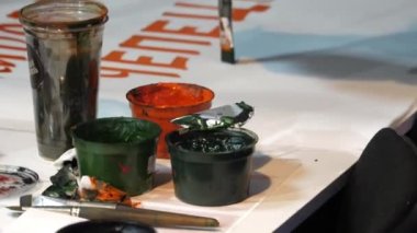 Spor taraftarı, yerel hokey takımını desteklemek için Gouache boyası yakın görüşlü büyük kağıt tabaka üzerinde pankart çiziyor