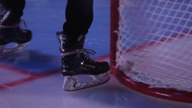 Buz pateni işçisi, yarı karanlık stadyumda buz pateni için buz sahası hazırlıyor.