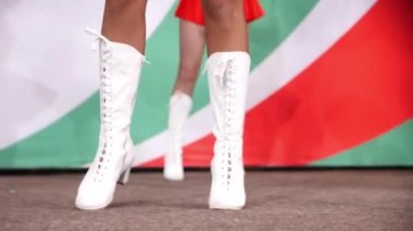 Beyaz çizmeli bayan ponpon kız dans ediyor. Hokey maçında destekçileri ve oyuncuları ağırdan alıyor.