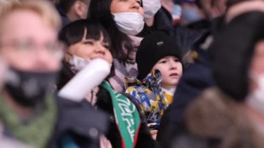 KAZAN, TATARSTAN RUSSIA - 15 Temmuz 2021: Anne, Kazan 'da 15 Temmuz' da stadyumun kapalı çekimlerinde hokey oyuncularına destek olmak için çığlık atan mutlu küçük çocuğu tutuyor