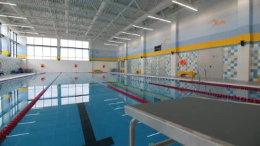 Modern atletizm merkezinde sporcular için temiz mavi su ve ekipmanla çağdaş yüzme havuzu.