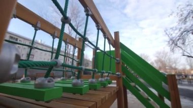 Çocuk eğlence parkında halat ve tahtalarla köprü kış günü kapalı manzaralı konut binalarının bahçesinde.