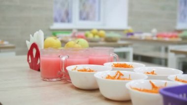 Meyve içecekleri ve okul kantinindeki çocuklar için taze havuç salatası. Öğrenciler için sağlıklı beslenme