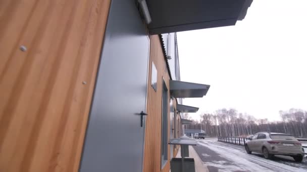 雪の街の近くのビューの教室への独立した入り口を持つ現代的な学校の建物の前の動き — ストック動画