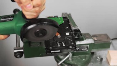 İşçi, stüdyonun en yakın görüntüsünde dairesel testereyle sabit disk sürücüsünü kesiyor. Donanım ve veriler yok ediliyor