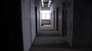 Binayı restore ederken pencerenin altında kapı ve radyatör bulunan yarı-karanlık boş koridor. Okul inşaatı