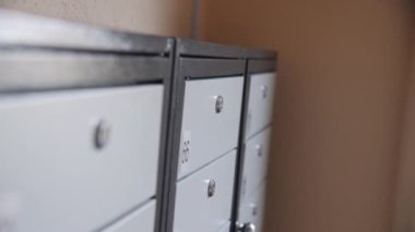 Koridorun sonundaki apartmanın duvarında kapalı metal posta kutuları var. Kiracıların rahatı için eşyalar