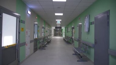 Boş uzun koridor, sandalyeler ve yenilenmiş okul binasının kapalı sınıf kapıları. Basit iç tasarım