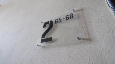 Saydam plastik isim plakası. Bina giriş zemininin numarası ve beyaz duvar manzaralı daireler.
