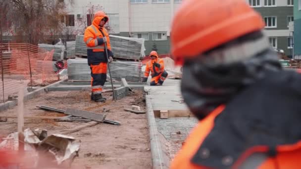 哈萨克斯坦 塔塔拉斯坦 2021年10月5日 身穿橙色制服的建筑工人在新的城市公园缓慢移动的过程中以混凝土砖铺成的道路 2005年10月5日在喀山的城市发展 — 图库视频影像