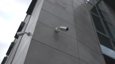 Şehir caddesinin aşağısındaki modern ofis merkezinin duvarlarındaki güvenlik kameraları. Güvenlik ekipmanı