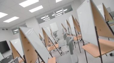 Boş sanat okulunda beyaz tahta katlayan işyerleri kapalı sınıf kameraları ters dönerler. Eğitim ekipmanları