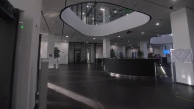 Resepsiyonlu koridor ve zarif çok katlı otel binasının tavanında cam kubbe. Gelecekçi mimari eğilimler