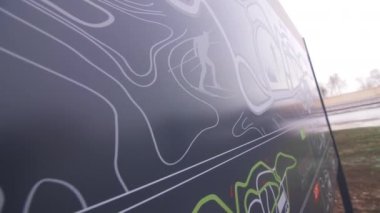 Çağdaş spor okulunun siyah kalkanındaki kayakçının resmi. Arka ışık çok yakın çekim. Kış sporları disiplini