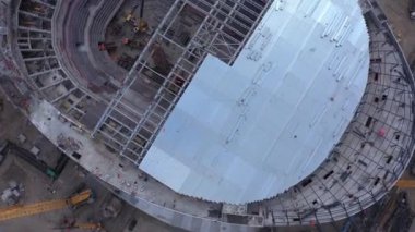 İnşaat alanı kuş bakışı görüşünde vinçleri olan hokey stadyumunun çatısının montajı. Teknoloji ve endüstri