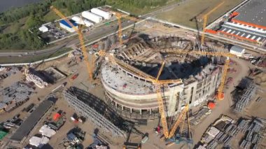 Güneşli bir günde şehrin inşaat sahasında güçlü kule vinçleri olan spor arena binaları inşa ediliyor.