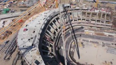 Çağdaş stadyum binasının beton leşi ve güneşli yaz günü hava manzaralı inşaat sahasında çatı detayı.