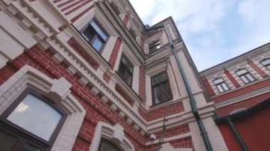 Kırmızı ve beyaz cepheli, şehir sokaklarında eski ve zarif binaların kemerli camları var. Eski mimari