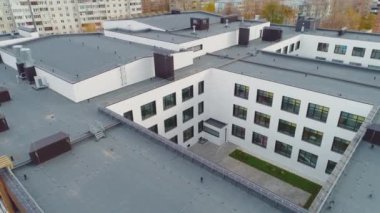 Sonbahar günü şehir merkezinde düz çatılı modern okul binasının avlusu. Şehir mimarisi