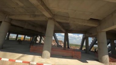 Stadyum inşaatının gri beton leşi ve inşaat alanındaki profesyonel işçiler yaz mevsiminin ilk günündeler.