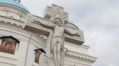 KAZAN, TATARSTAN RUSSIA - 09 Ekim 2021: İsa ile taş haç ve geleneksel ortodoks Hıristiyan kilisesi binasının bahçesindeki yazıtlar 09 Ekim 'de Kazan' da bulutlu bir günde kapatıldı