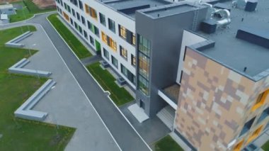 Büyük şehir hava manzaralı yerleşim bölgesinde dekore edilmiş yüzüyle okul binası. Mimarlık ve eğitim