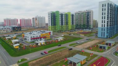Bulutlu bir günde, şehir merkezindeki büyük yerleşim yerlerinin yakınında boş çocuk parkları olan parlak anaokulu.