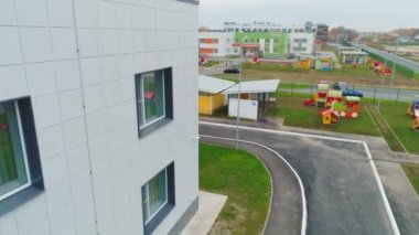 Yeni kasaba hava manzaralı yerleşim yerlerinin yakınında oyun setleri olan anaokulu çevresinde hareketlilik