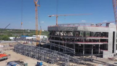 Şehrin hava manzaralı inşaat alanındaki spor stadyumunun yakınındaki vinç yelkenlerine büyük çelik parçaları asılıyor.