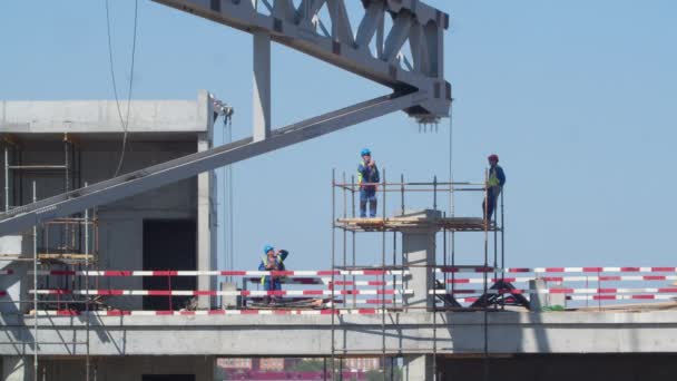 俄克拉荷马州奥斯特克 2021年9月15日 工人们站在地上 大型金属框架在蓝天的映衬下倒塌在体育场建筑工地上 — 图库视频影像