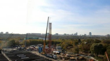 Çağdaş kule vinçlerinin mevsim boyunca büyük inşaat sahasında faaliyet süreleri. İnşaatta makineli kargo taşıyorum. Şehir Geliştirme