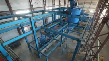Malzemelerin ve işleme ekipmanlarının fabrikadaki metal leşlerin üzerindeki sarnıçlarla birlikte zaman ayarlı kurulumu. Atölyede üretim teknolojisi. Fabrika tasarımı ve inşaatı
