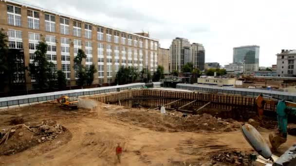 挖掘机和卡车起重机在工地地面上运行的时间 发展城市基础设施 新大楼的准备工作 — 图库视频影像