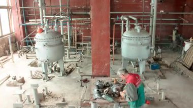 Tesis atölyesine haftalarca kurulacak boru hattı ve metal tankların zaman çizelgesi. İşçi tugayı üretim ekipmanlarını birleştiriyor