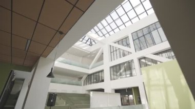 Şık bir iş merkezinde geniş koridor ve yüksek cam tavan. Kamu binaları için ergonomik tasarım çözümleri