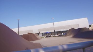 KAZAN, TATARSTAN RUSSIA - 27 Haziran 2021: Genç kadın bisiklet sporları yarışmalarını telefon kamerasıyla çekiyor. Bisiklet sürücüsü 27 Haziran 'da Kazan' da sıçrama tahtasında başarılı bir şekilde hile atlayışı gerçekleştirdi