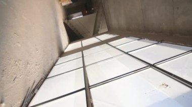 İnşaat alanında cam cepheli ve beton duvarlı gelecekteki alışveriş merkezi binasının boş koridoru boyunca hareket