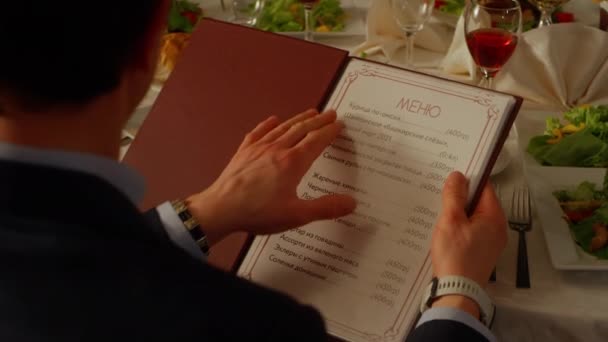 Homme Choisit Des Plats Dans Menu Restaurant Assis Table Servie — Video
