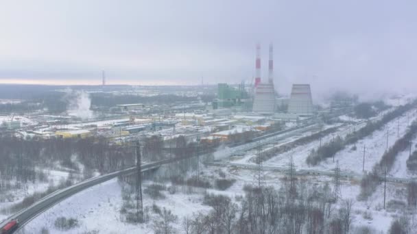 冬の空の景色に霧で覆われた大規模な加熱工場の冷却塔と煙突 産業景観 — ストック動画