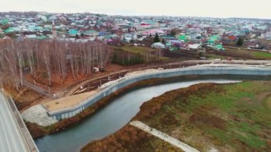 Dar nehrin üzerinde, sonbahar parkı hava manzaralı, yeniden inşa edilmiş toprak seti olan bir köprü. Şehir manzarası