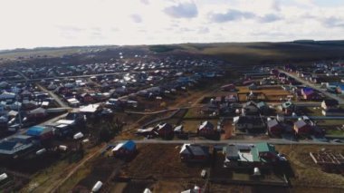 Kır manzaralı tepelere karşı konforlu binaları ve yolları olan büyük bir köy. Banliyö bölgesi