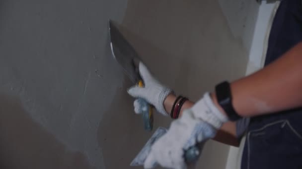 作業員は 修復された前提を閉じスローモーションでパテと壁に石膏を置きます 復元された建物の内部の表面をカバー — ストック動画