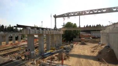 Yaz mevsiminde inşaat alanında beton kiriş montajı yapan tren istasyonunun zaman çizelgesi. Kentsel altyapı gelişimi
