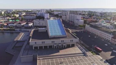 Şehir kuş bakışı modern sette mavi çatılı nehir iskele terminali. Yaz akşamında şehir panoraması