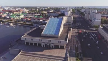 Gün batımında hava manzaralı sakin nehir kıyısındaki rıhtım terminali. Büyük çağdaş şehrin simgesi